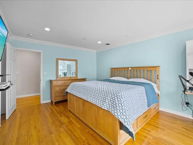 a bedroom with a large bed and a wooden floor