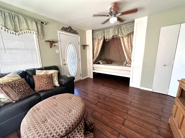 a living room with furniture and a wooden floor
