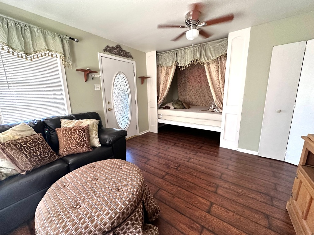 a living room with furniture and a wooden floor