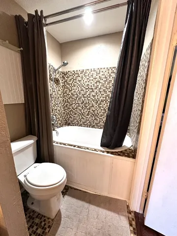 a bathroom with a toilet and a shower