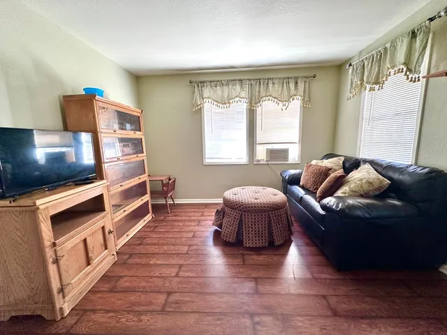a living room with furniture windows and a flat screen tv