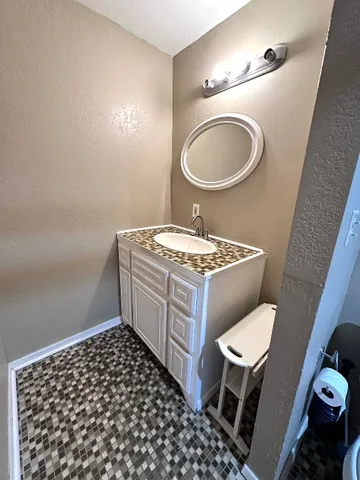 a bathroom with a granite countertop toilet a sink and a mirror