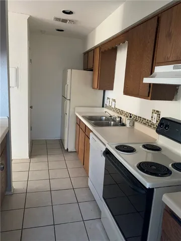 a kitchen with a sink a stove and a refrigerator