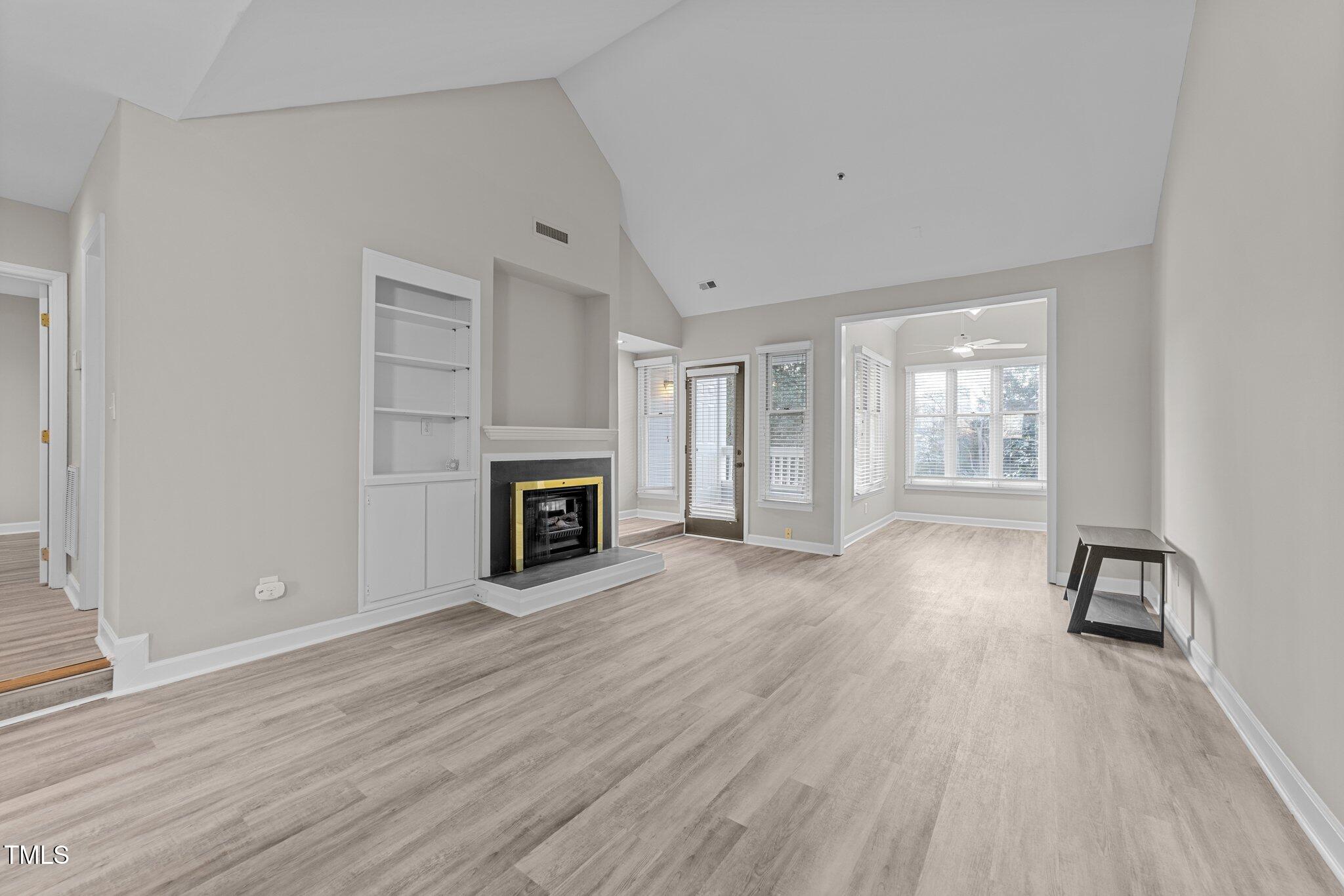 243 New Bern Place, Unit 301 Raleigh, NC 27601 - Photo 10 of 31 wooden floor fireplace and windows in an empty room