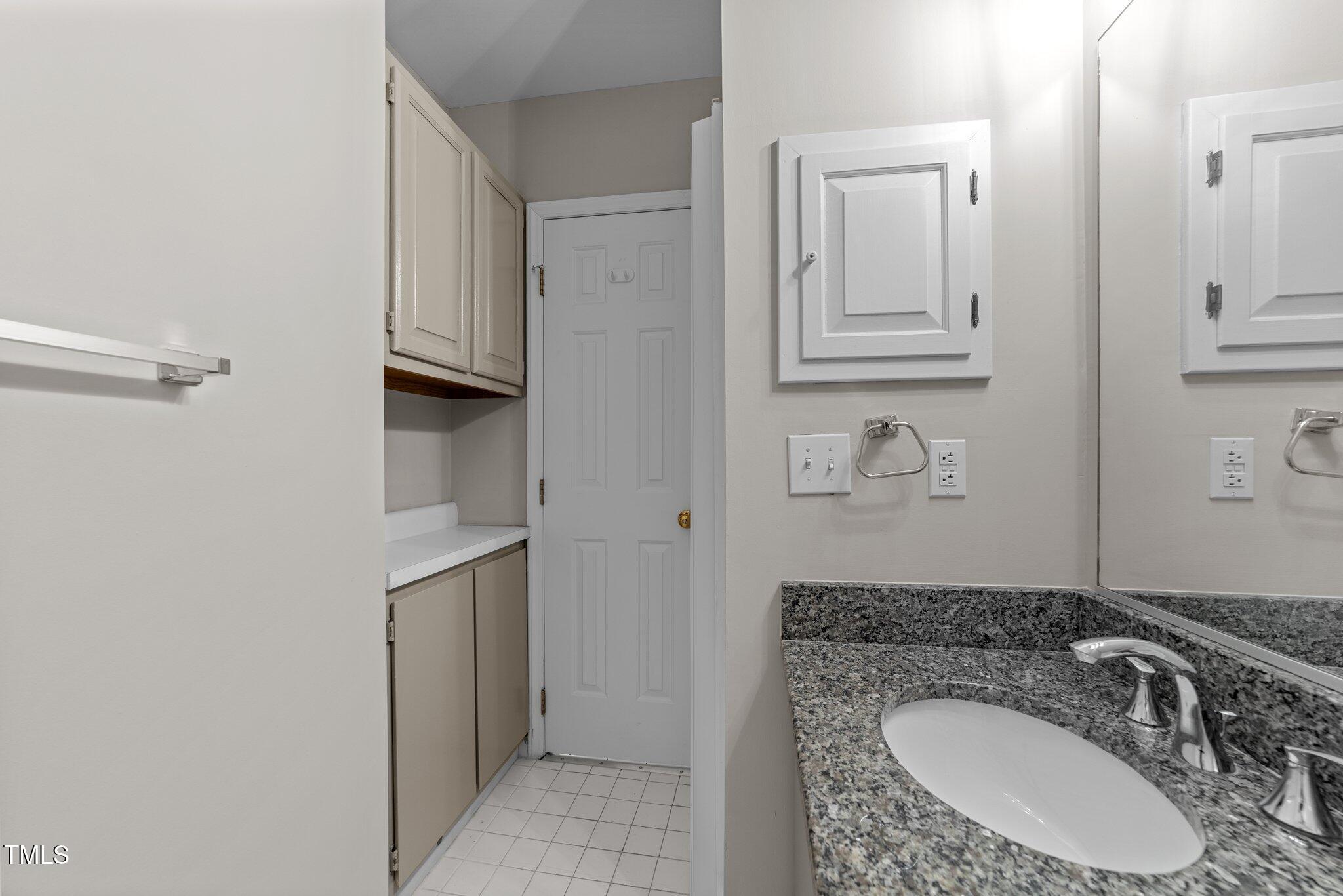 243 New Bern Place, Unit 301 Raleigh, NC 27601 - Photo 22 of 31 a bathroom with a granite countertop sink and a mirror