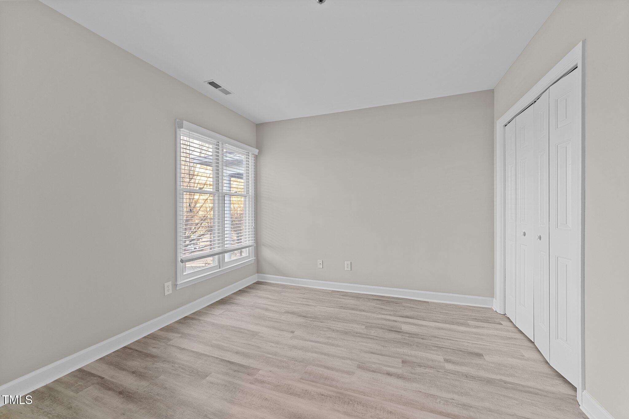 243 New Bern Place, Unit 301 Raleigh, NC 27601 - Photo 24 of 31 a view of an empty room with wooden floor and a window