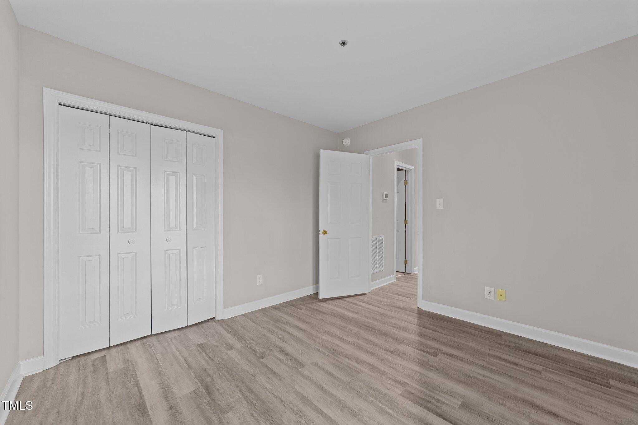 243 New Bern Place, Unit 301 Raleigh, NC 27601 - Photo 25 of 31 a view of an empty room with wooden floor