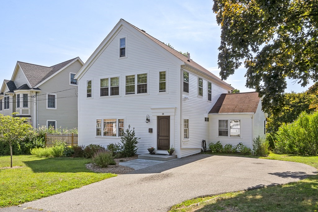 a front view of a house with a yard and trees