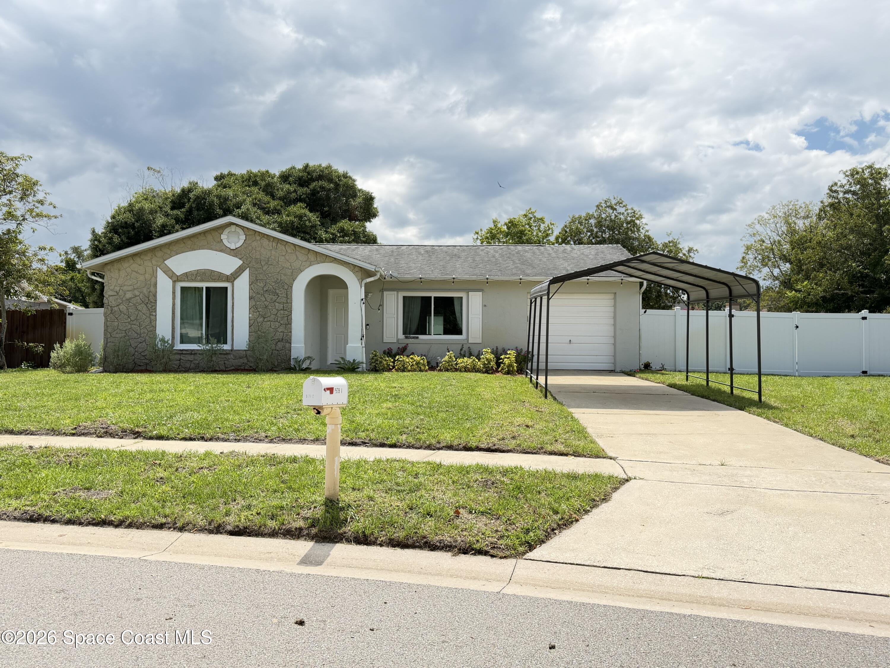 1578 West Powder Horn Road Titusville, FL 32796 - Photo 2 of 22 a front view of a house with a garden and garage