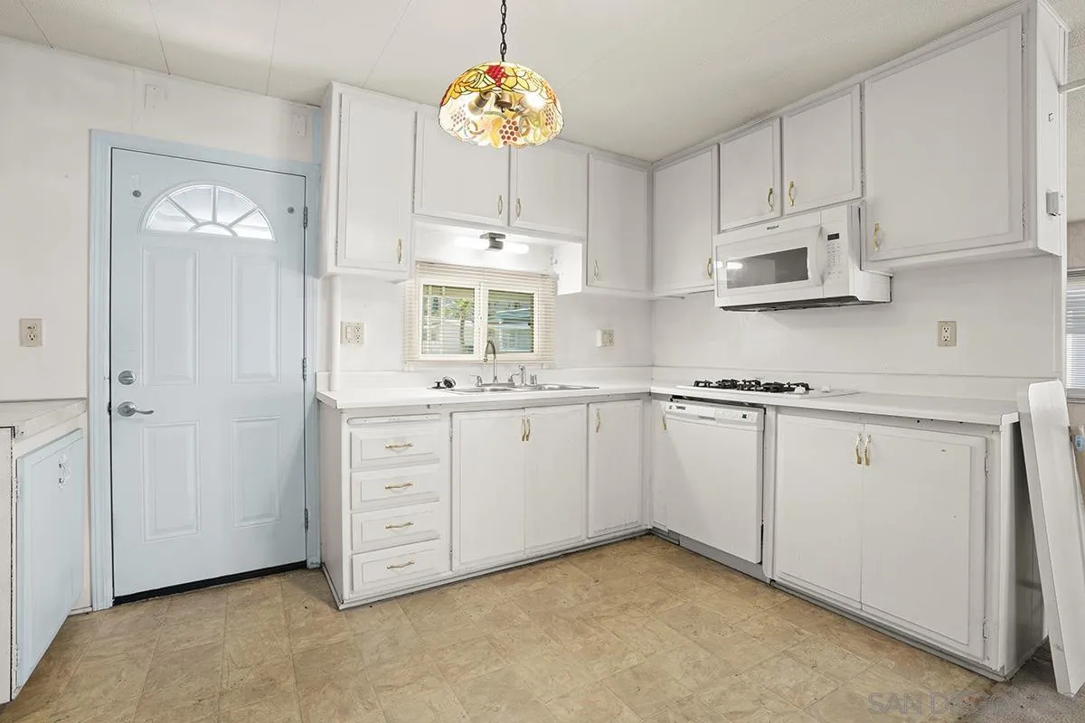 8545 Mission Gorge Road, Unit 239 Santee, CA 92071 - Photo 19 of 26 a kitchen with cabinets stainless steel appliances and a chandelier