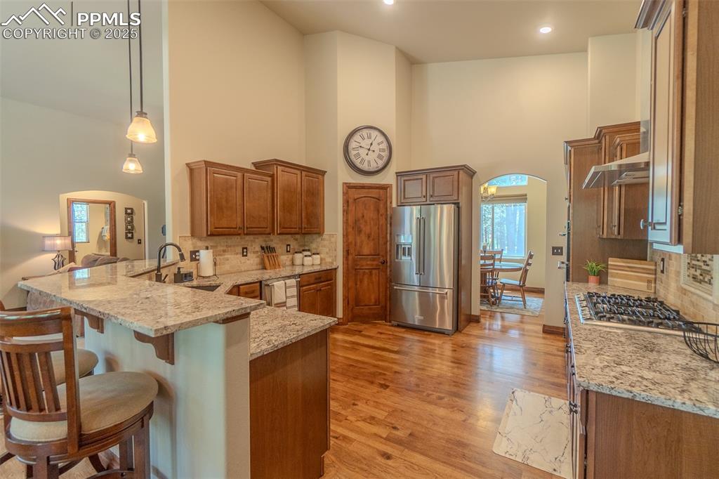 15324 Pole Pine Point Colorado Springs, CO 80908 - Photo 14 of 50 a kitchen with a table chairs and a clock on the wall