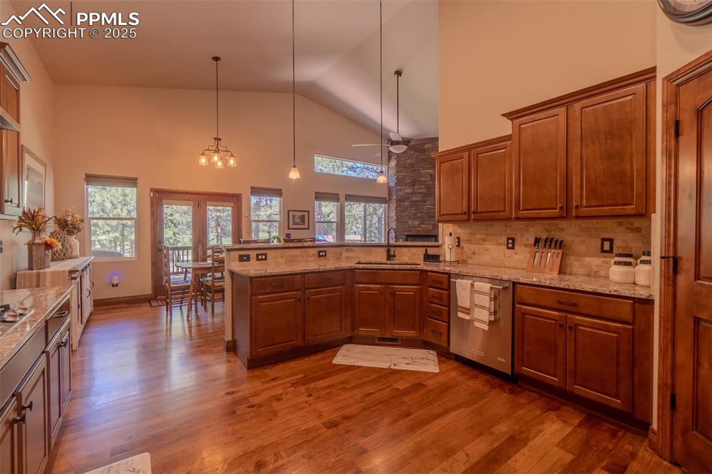 15324 Pole Pine Point Colorado Springs, CO 80908 - Photo 16 of 50 a kitchen with stainless steel appliances granite countertop wooden floors a stove and a refrigerator