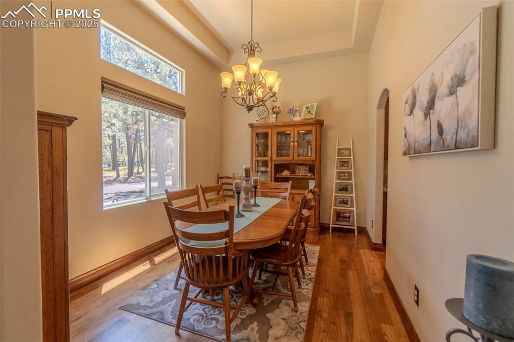 15324 Pole Pine Point Colorado Springs, CO 80908 - Photo 18 of 50 a dining room with furniture a chandelier and wooden floor