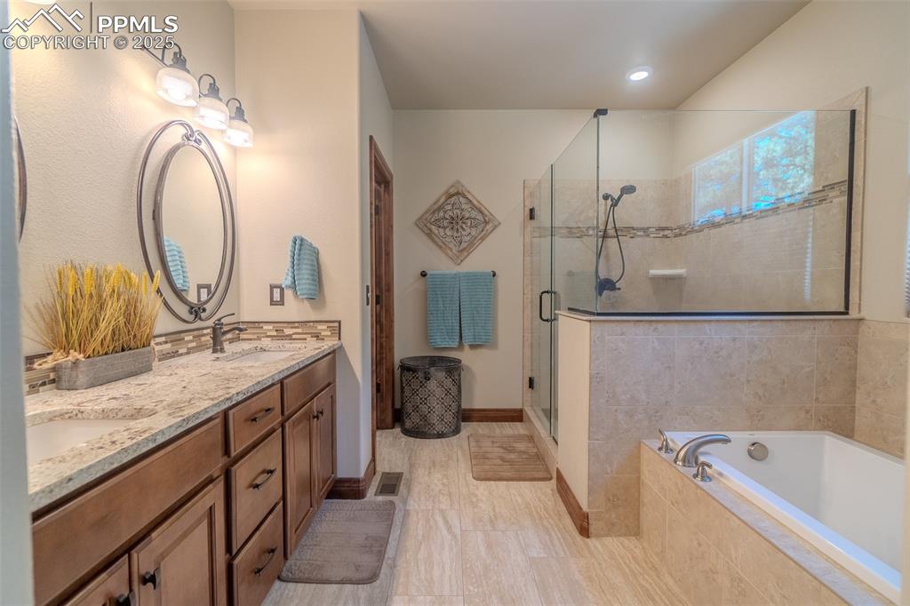 15324 Pole Pine Point Colorado Springs, CO 80908 - Photo 21 of 50 a bathroom with a granite countertop sink mirror vanity and bathtub