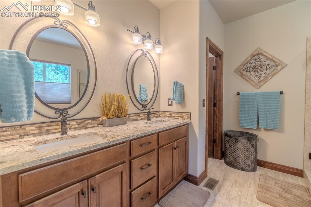 15324 Pole Pine Point Colorado Springs, CO 80908 - Photo 22 of 50 a bathroom with a granite countertop sink a mirror and vanity