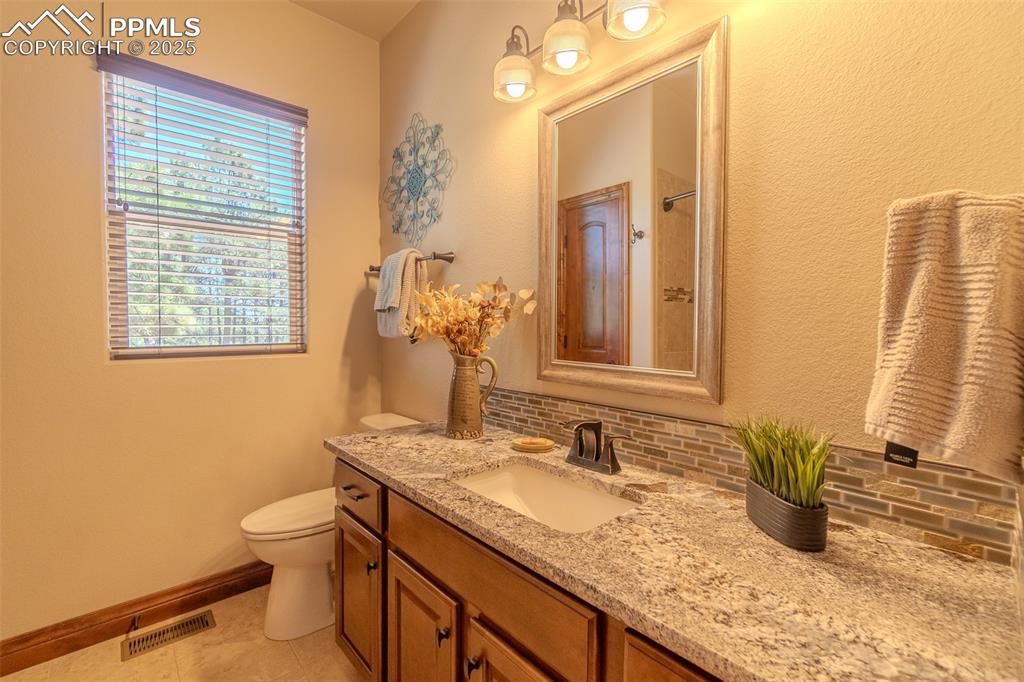 15324 Pole Pine Point Colorado Springs, CO 80908 - Photo 27 of 50 a bathroom with a granite countertop sink and a mirror