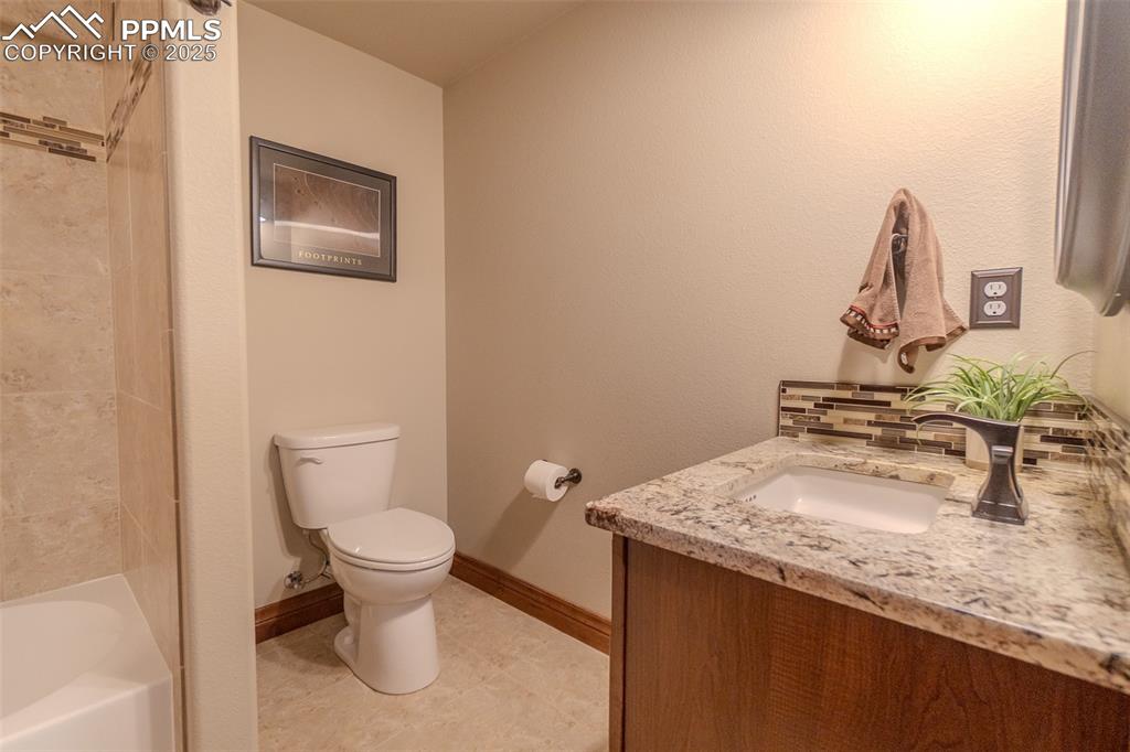 15324 Pole Pine Point Colorado Springs, CO 80908 - Photo 38 of 50 a bathroom with a granite countertop sink and a toilet