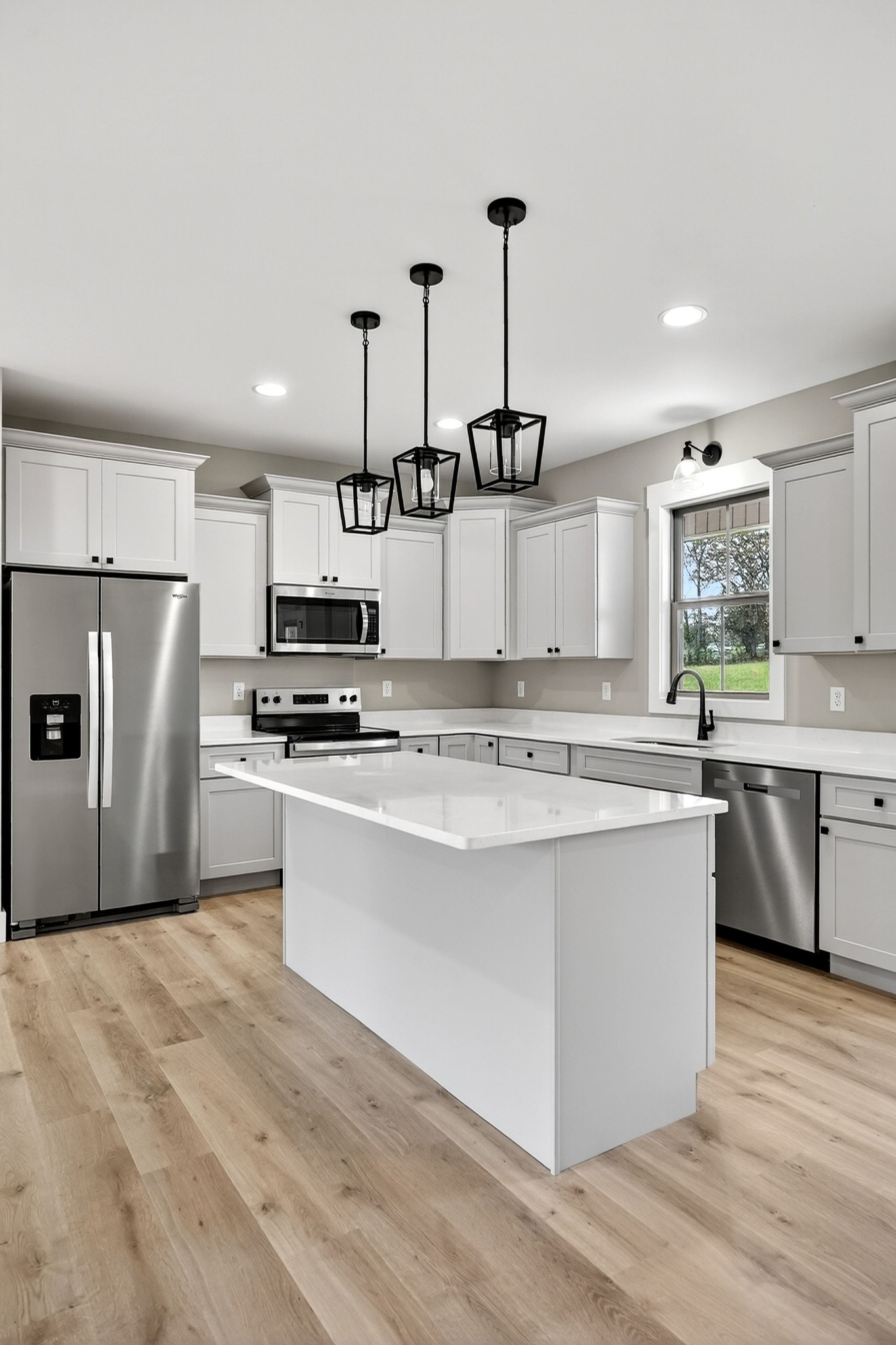 136 East McCormick Road Livingston, TN 38570 - Photo 13 of 29 a kitchen with stainless steel appliances kitchen island granite countertop a stove a sink dishwasher a refrigerator and white cabinets with wooden floor