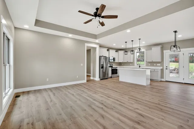 a view of a kitchen with wooden floor and a ceiling fan