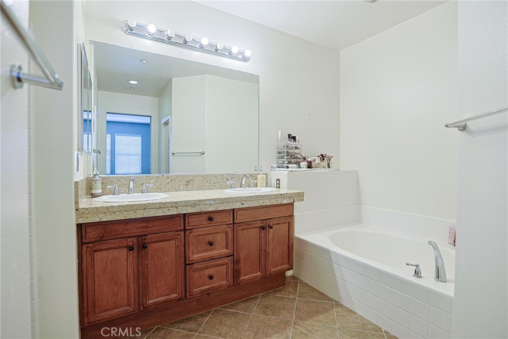 416 Quail Ridge Irvine, CA 92603 - Photo 14 of 23 a bathroom with a tub a double vanity sink and a mirror