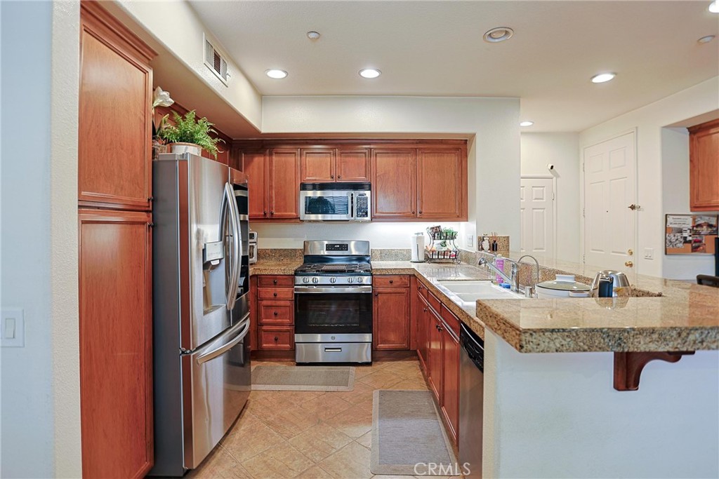 416 Quail Ridge Irvine, CA 92603 - Photo 5 of 23 a large kitchen with stainless steel appliances granite countertop a stove refrigerator and a sink