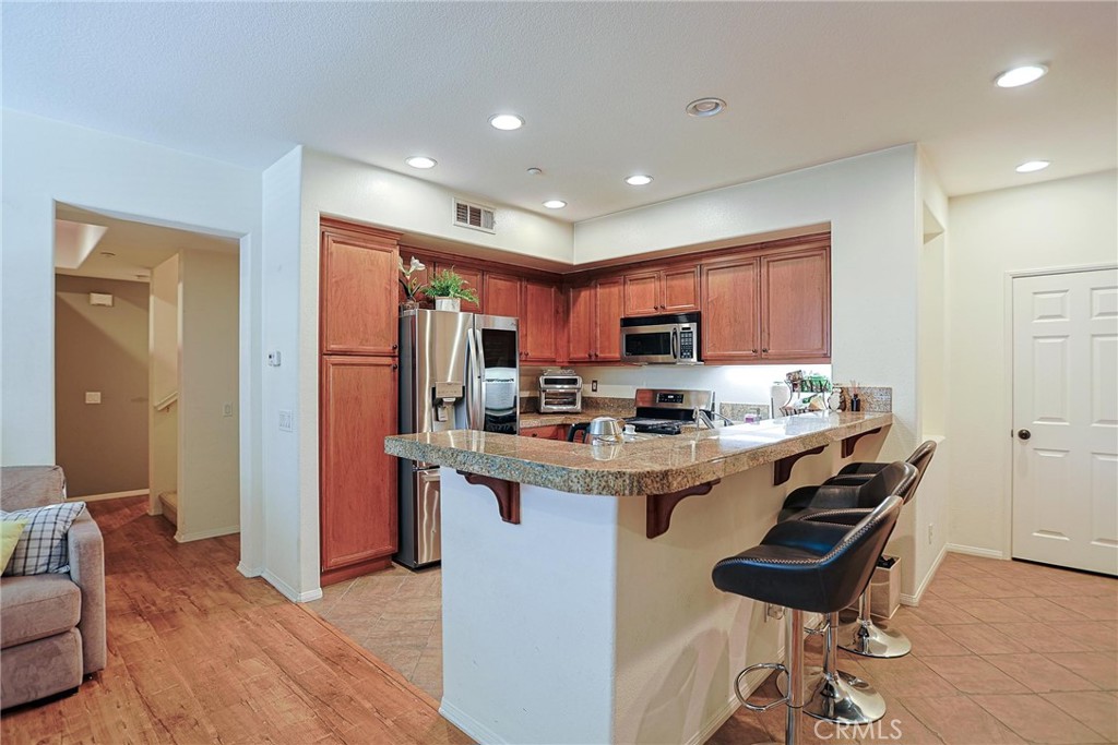 416 Quail Ridge Irvine, CA 92603 - Photo 6 of 23 a kitchen with granite countertop a sink a counter top space stainless steel appliances and cabinets