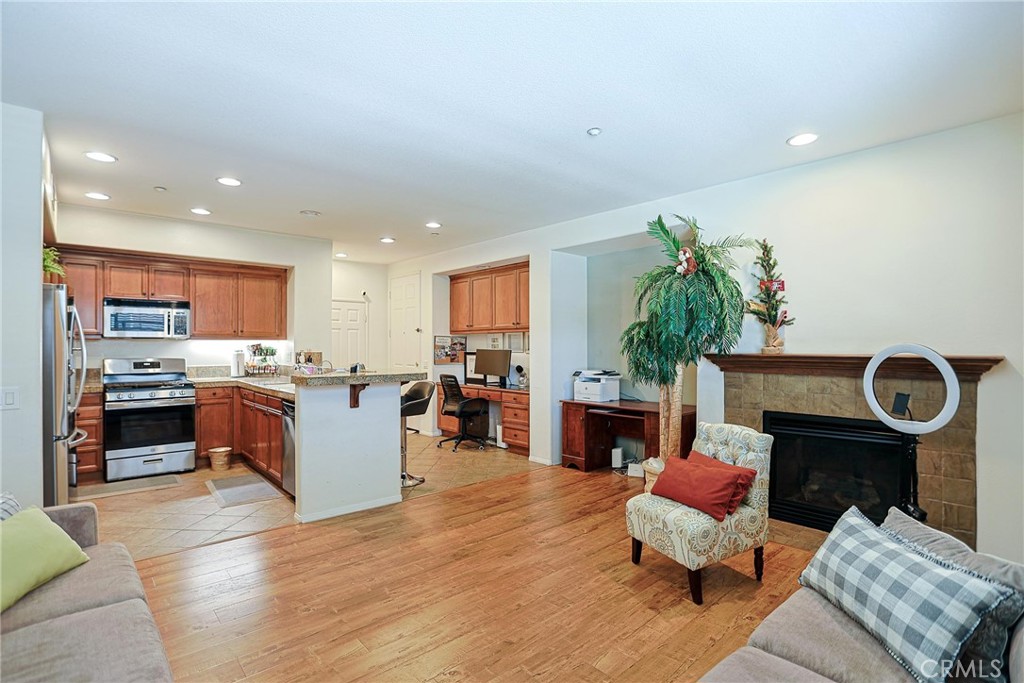 416 Quail Ridge Irvine, CA 92603 - Photo 8 of 23 a living room with furniture a fireplace and a kitchen view