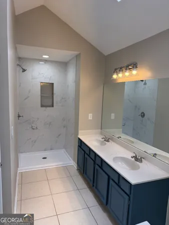 a bathroom with a sink a shower and a mirror