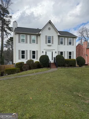 a front view of a house with a garden