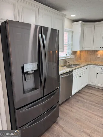 a kitchen with stainless steel appliances a refrigerator sink and cabinets