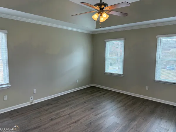 a view of an empty room with window and wooden floor