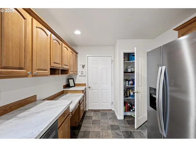 a kitchen with stainless steel appliances granite countertop a refrigerator and a sink