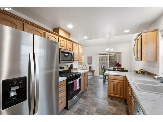 a kitchen with stainless steel appliances granite countertop a refrigerator stove and sink