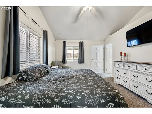 a bed room with a bed a television and a window