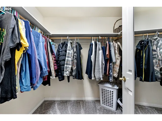 a view of walk in closet with clothes