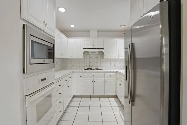 a kitchen with cabinets appliances a sink and a window