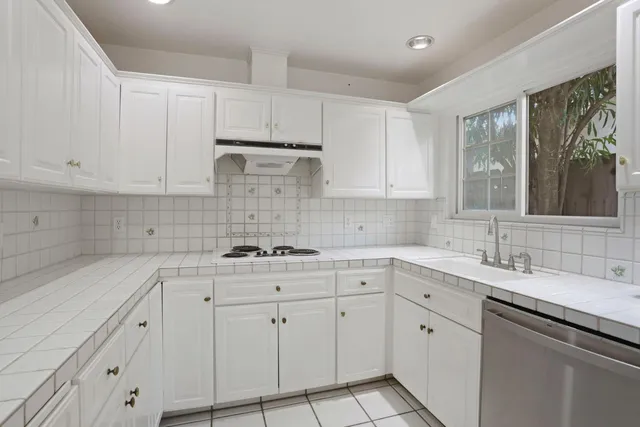 a kitchen with white cabinets and appliances