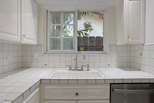 an empty room with wooden floor cabinet and windows