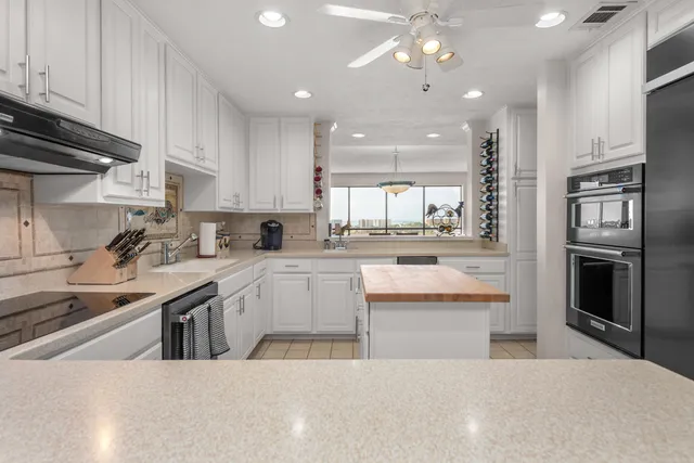a kitchen with white cabinets appliances and a sink