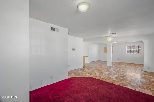 a large white kitchen with a sink and chandelier