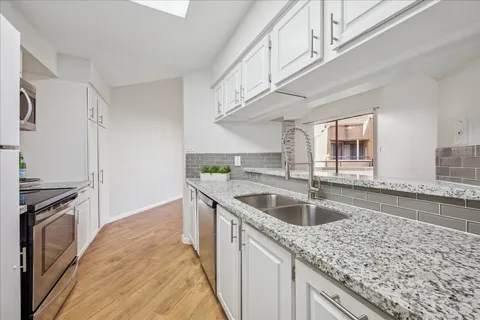 a kitchen with granite countertop a sink and a stove