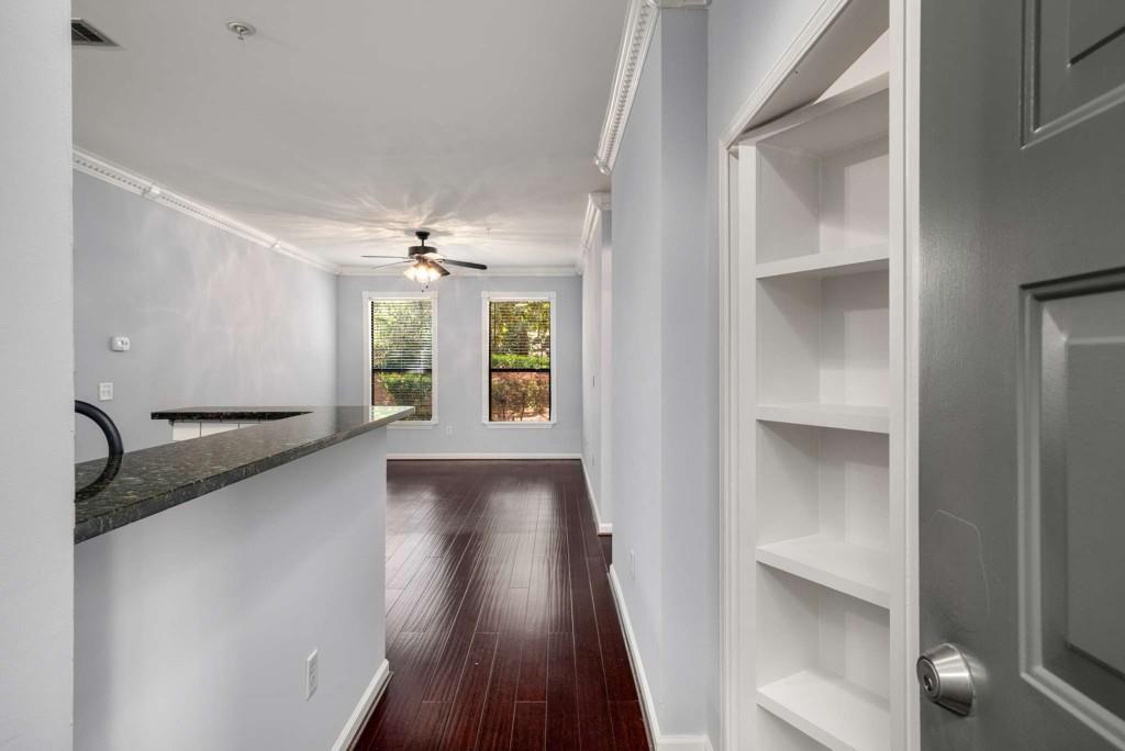 a view of a hallway with wooden floor and a window