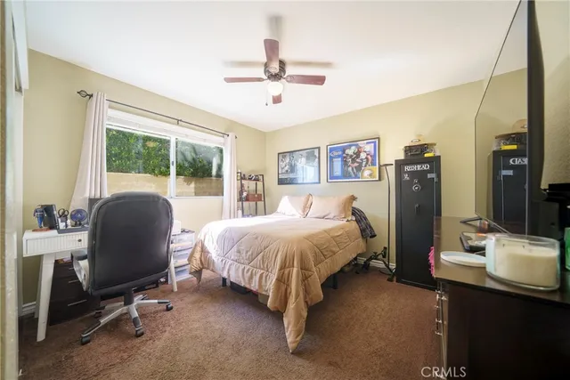 a living room with furniture a flat screen tv and a refrigerator