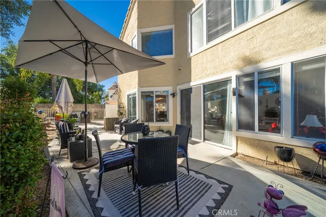 a view of a patio with couches table and chairs and potted plants