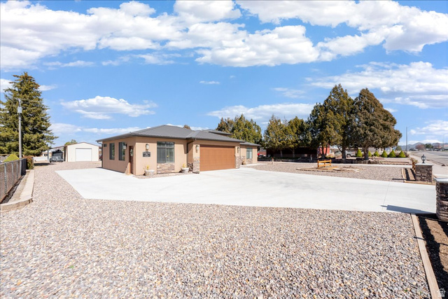 357 East Main Street Enterprise, UT 84725 - Photo 4 of 71 View of front of house featuring concrete driveway, stucco siding, stone siding, and a garage