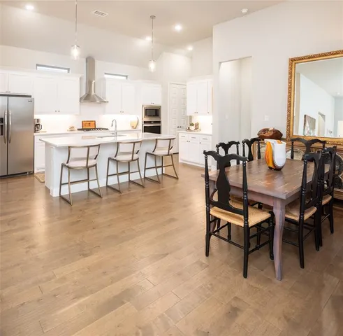a dining room with kitchen island furniture a flat screen tv and kitchen view