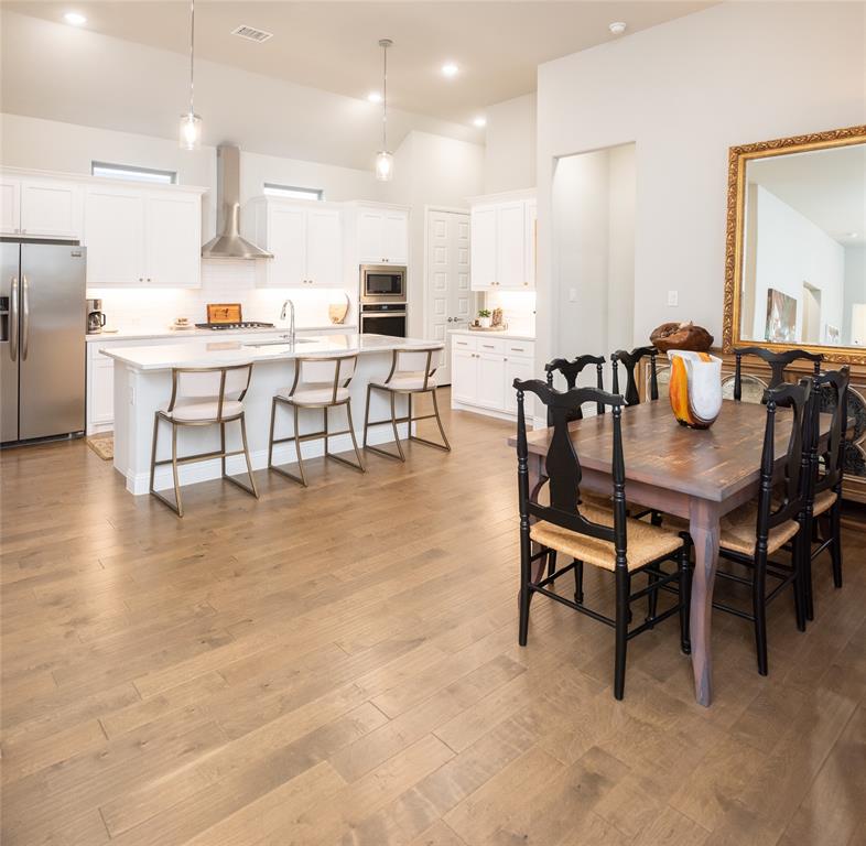 4841 Miles Way Fairview, TX 75069 - Photo 6 of 23 a dining room with kitchen island furniture a flat screen tv and kitchen view