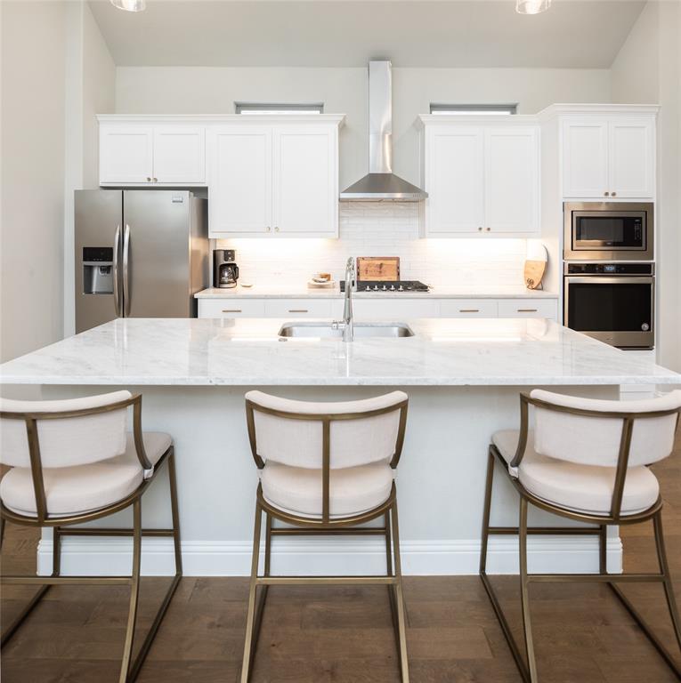 4841 Miles Way Fairview, TX 75069 - Photo 9 of 23 a kitchen with stainless steel appliances kitchen island granite countertop a table chairs and a refrigerator