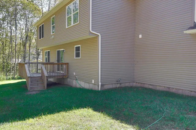 a balcony with wooden floor and yard in the back