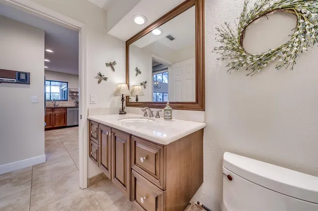 a bathroom with a double vanity sink a toilet and shower
